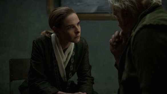 Juliette Nichols in her mayoral attire speaks with Bernard Holland in jail before his cleaning in Silo Season 3 Episode 9.