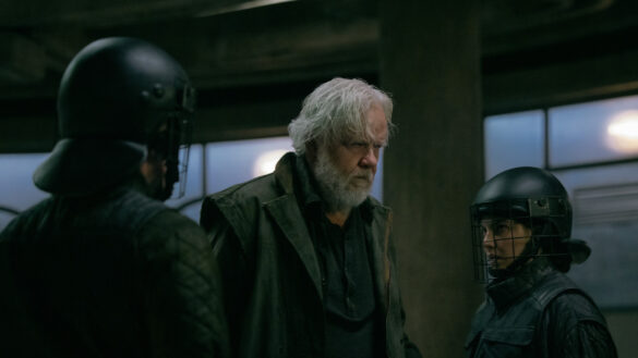 Tim Robbins as Bernard Holland walking with Raiders in Silo Season 3 Episode 9, “Farewell.”